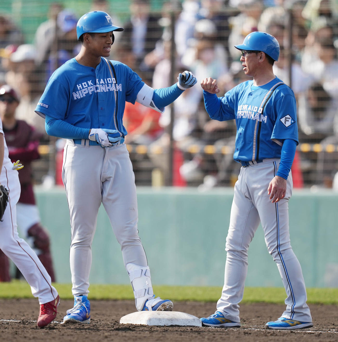 楽天対日本ハム　4回表日本ハム1死一、二塁、中前適時打を放った後、タッチを交わす日本ハム万波（左）（撮影・鈴木みどり）