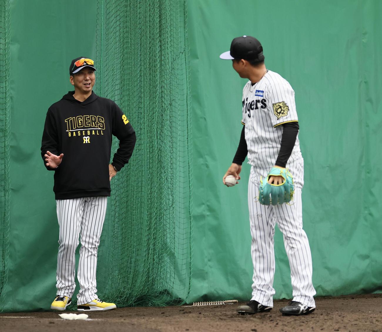 ブルペン投球の合間に、村上に指導する藤川監督（左）（撮影・藤尾明華）