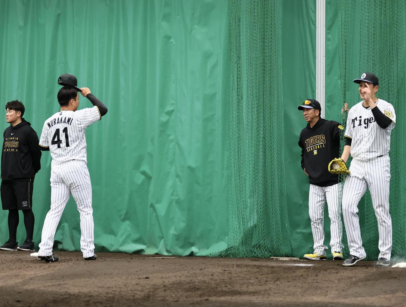ブルペン投球の合間に、村上に指導する藤川監督（右から2人目）（撮影・藤尾明華）