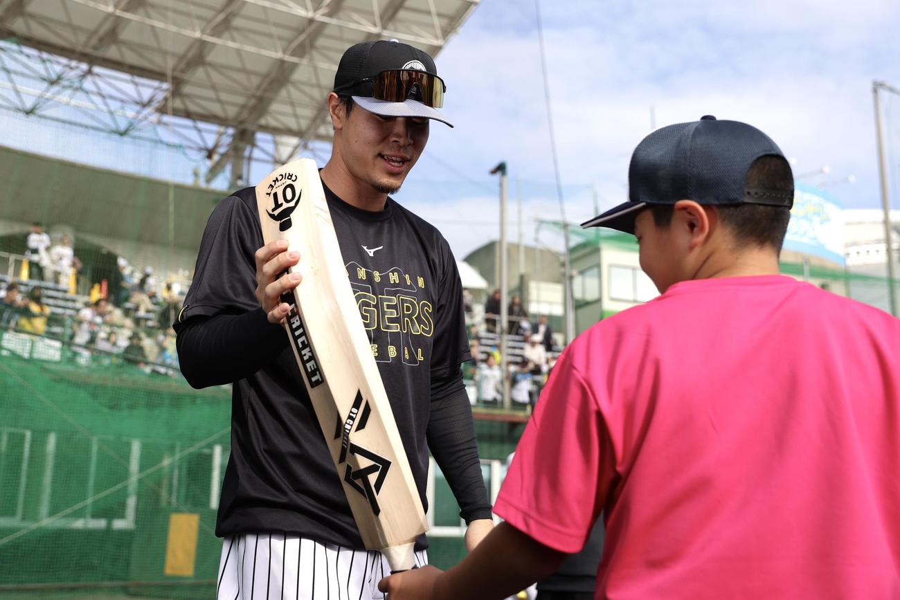 野球教室でクリケットバットを使って子どもたちを指導する阪神佐藤輝（撮影・前田充）