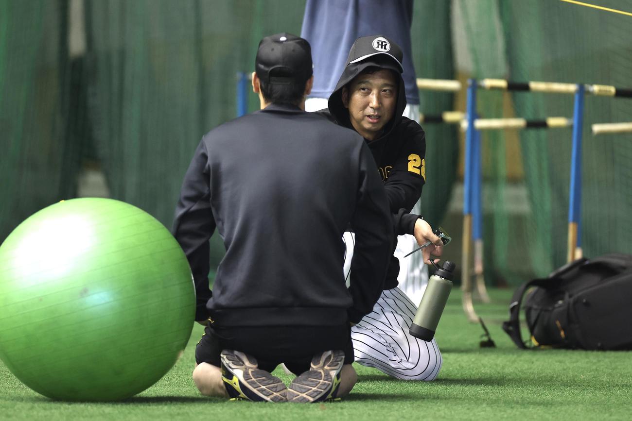 練習前、阪神佐藤輝（手前）と言葉を交わす藤川監督（撮影・前田充）
