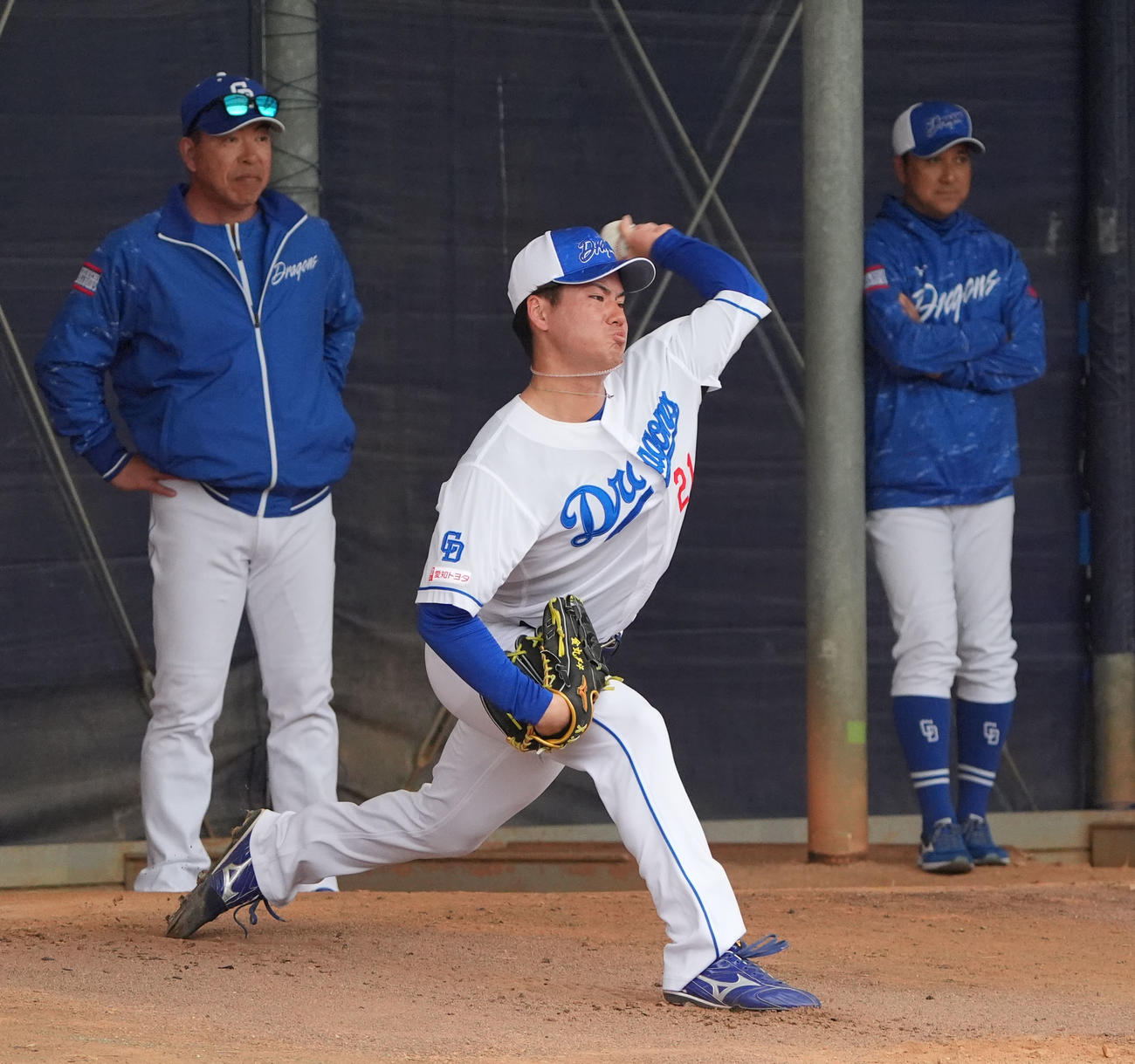 ブルペンで投球練習をする金丸（中央）奥・左から井上監督、落合2軍監督（撮影・森本幸一）