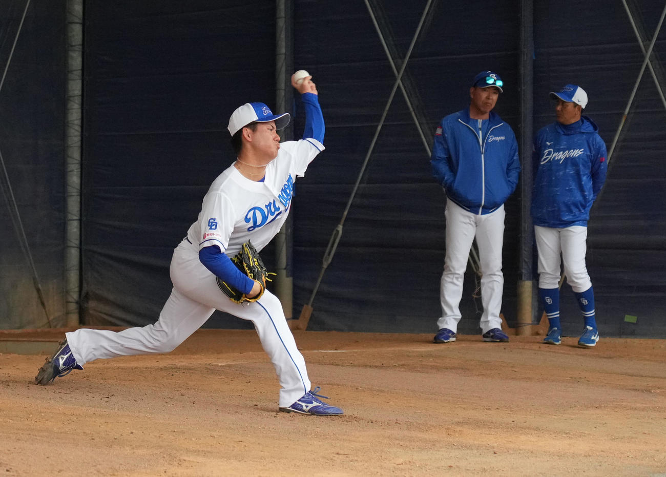 ブルペンで投球練習をする金丸（左）奥・左から井上監督、落合2軍監督（撮影・森本幸一）