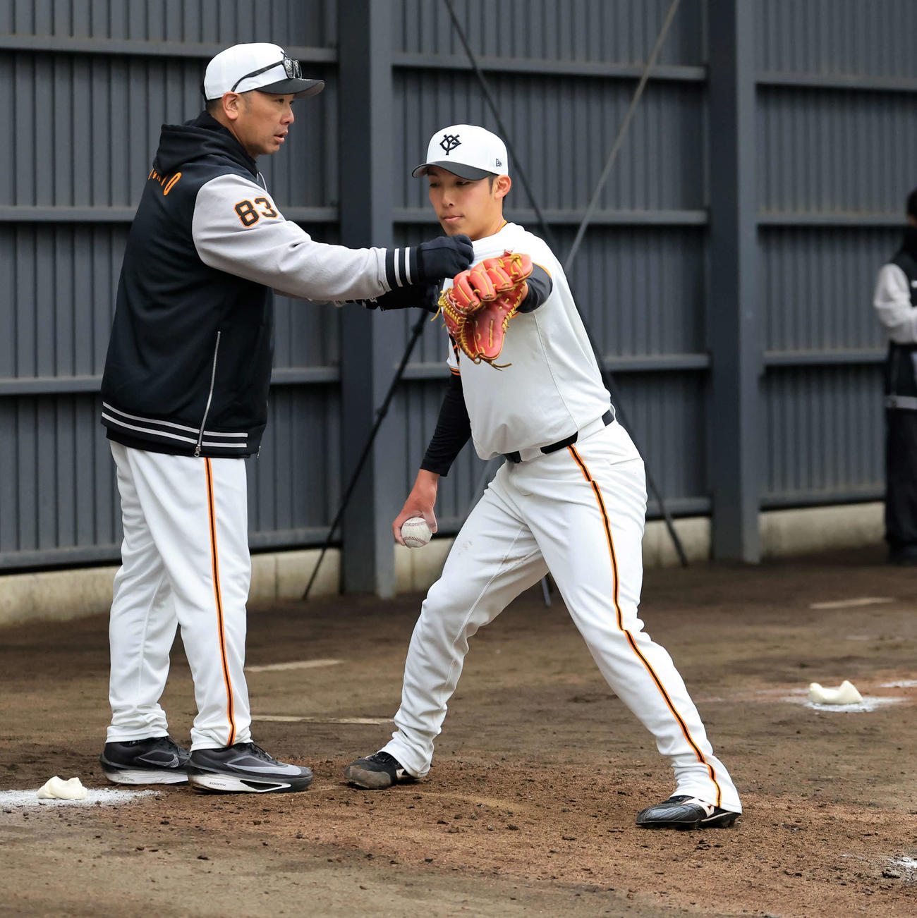 ブルペン投球中、巨人赤星（右）に指導する阿部監督（撮影・浅見桂子）