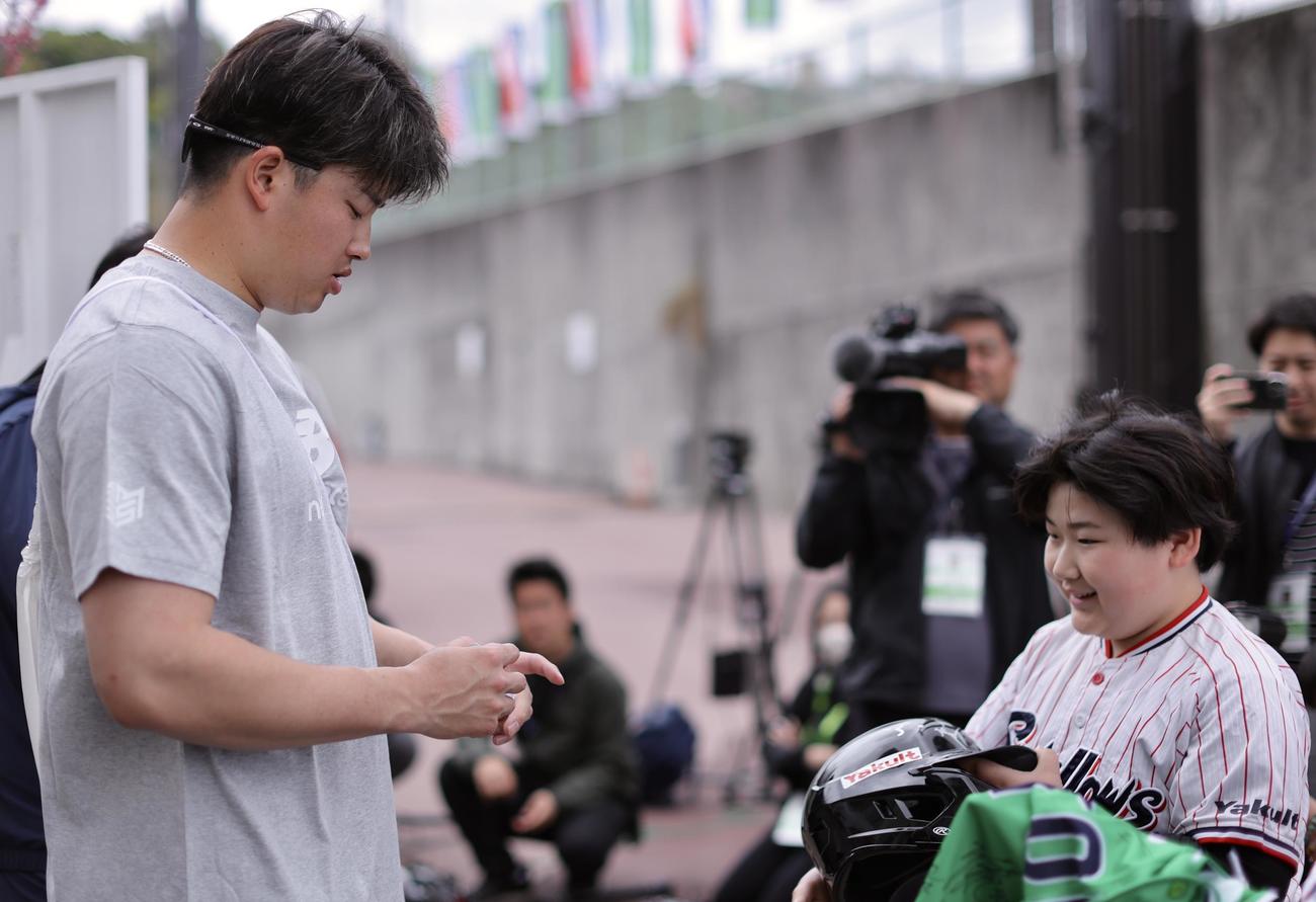 ユニホームを着たそっくりキッズにサインするヤクルト村上（撮影・河田真司）