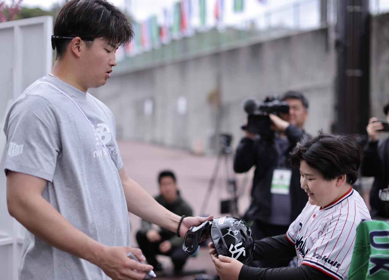 ユニホームを着たそっくりキッズにサインするヤクルト村上（撮影・河田真司）