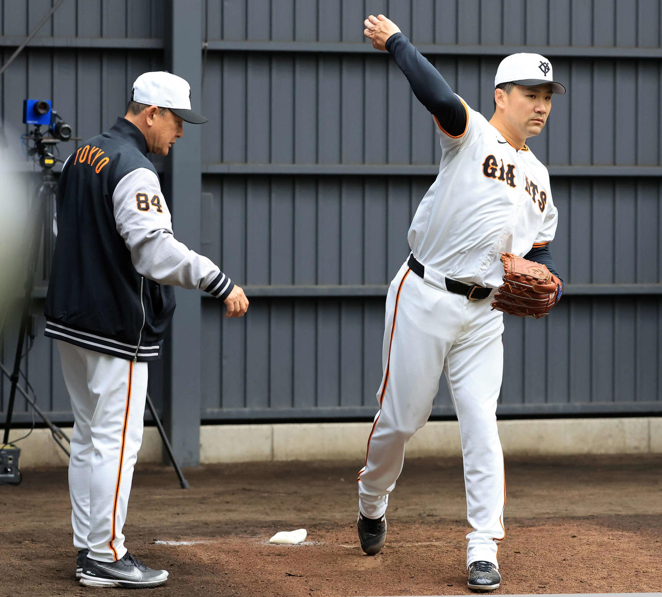 ブルペン投球後、巨人久保巡回投手コーチ（左）から動きを指導される田中将（撮影・浅見桂子）