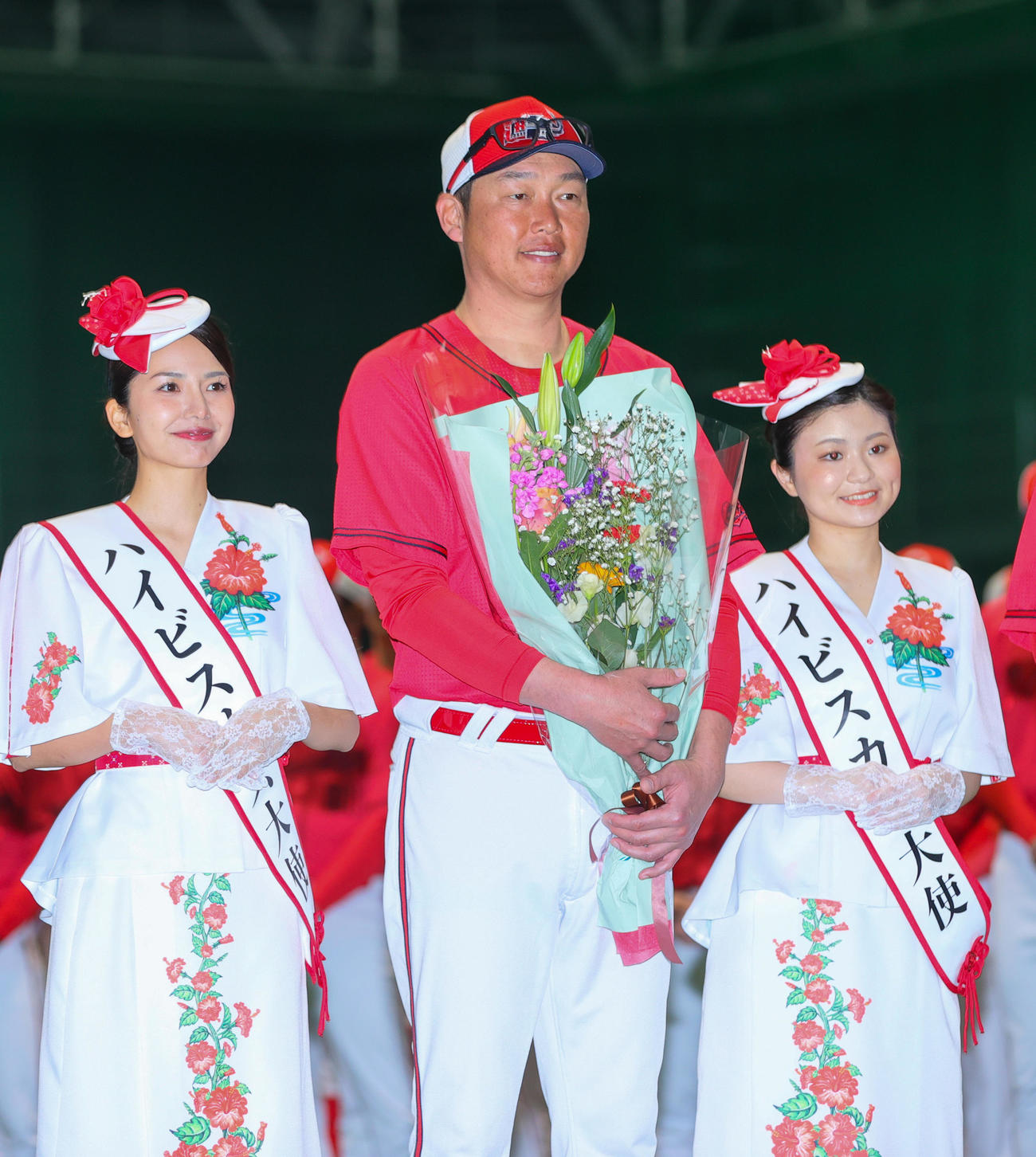 歓迎セレモニーでミスハイビスカスから花束を受け取り記念撮影する広島新井監督（中央）（撮影・上山淳一）