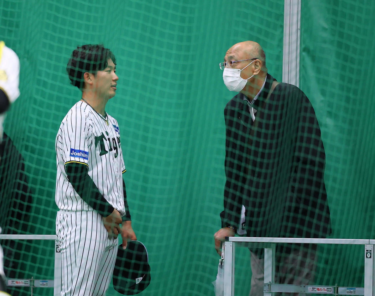 ブルペン投球を終え、大商大の先輩にあたる斎藤明雄氏（右）と話しをする伊原（撮影・藤尾明華）