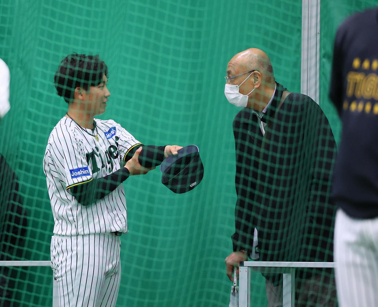 ブルペン投球を終え、大商大の先輩にあたる斎藤明雄氏（右）と話しをする伊原（撮影・藤尾明華）