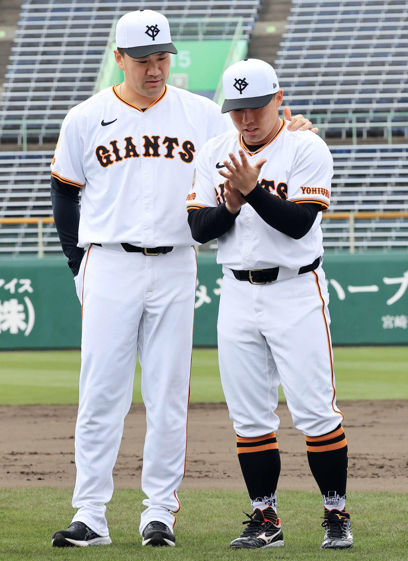 宮崎キャンプの手締めで並びながら、巨人浅野（右）は手の豆を田中将に見せる（撮影・浅見桂子）