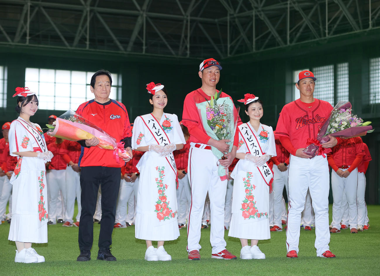 歓迎セレモニーでハイビスカス親善大使から花束を受け取り記念撮影する広島新井監督（左から4人目）と広島堂林（右）（撮影・上山淳一）
