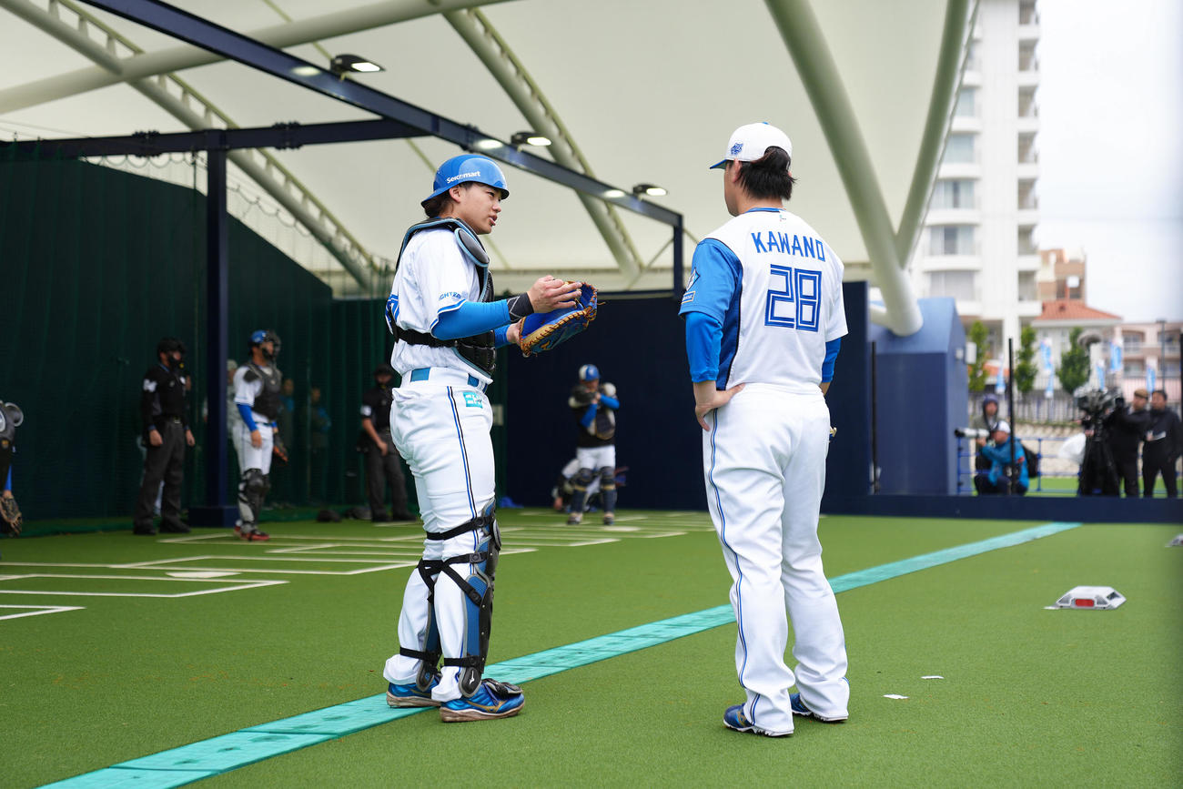 ブルペンで投球を終えた河野（右）に声をかける捕手田宮（撮影・足立雅史）