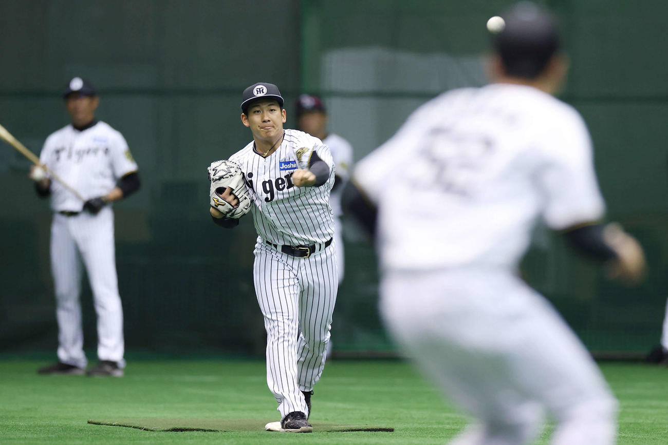 投内連係で二塁へ送球する阪神伊原（撮影・前田充）
