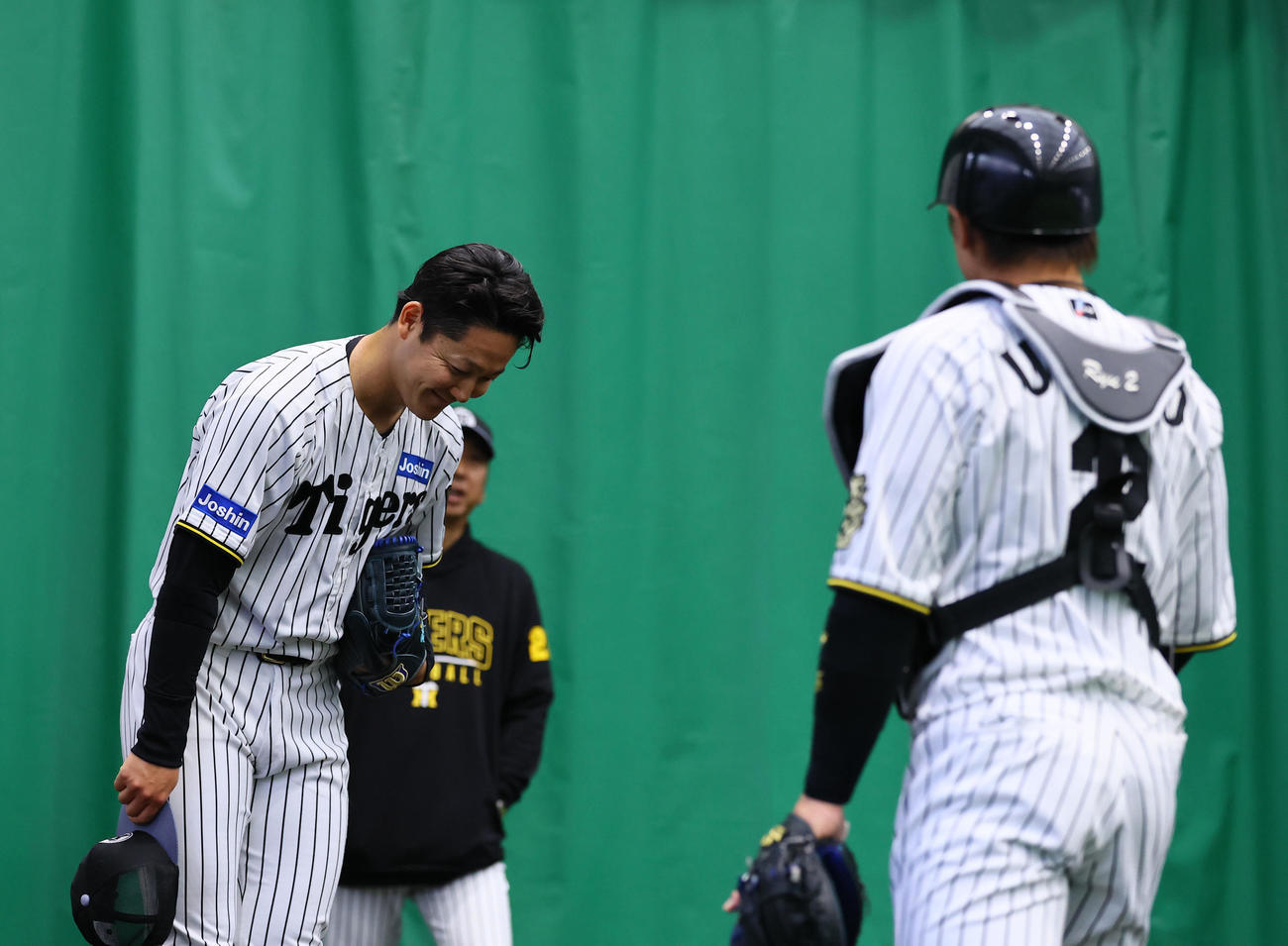ブルペン投球を終え、梅野（右）に一例する木下（撮影・藤尾明華）