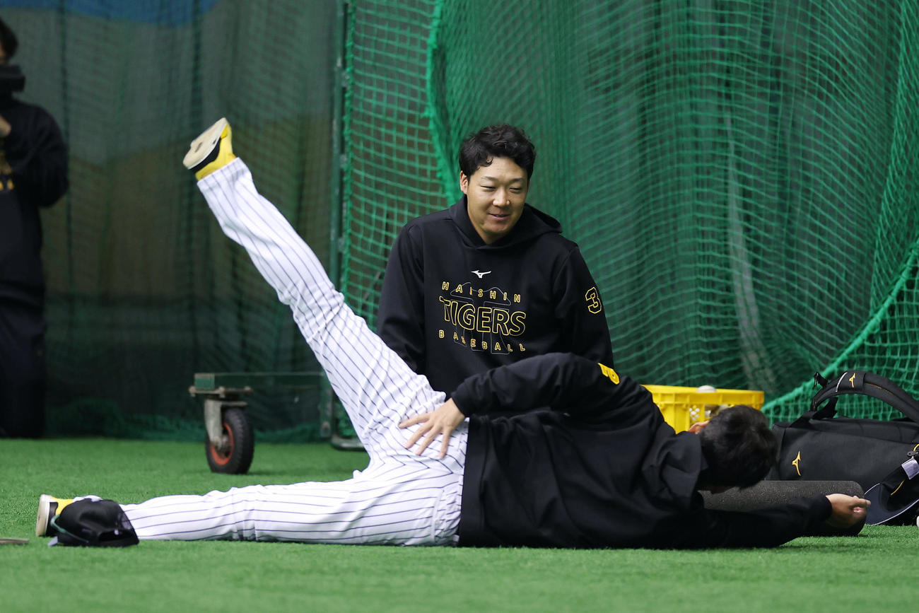 練習前、阪神藤川監督（手前）と言葉を交わす大山（撮影・前田充）