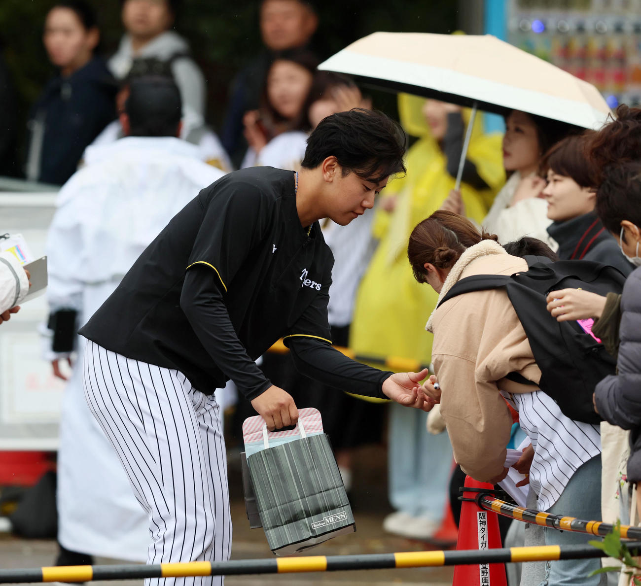 雨の中を待つファンにサインする門別（撮影・加藤哉）