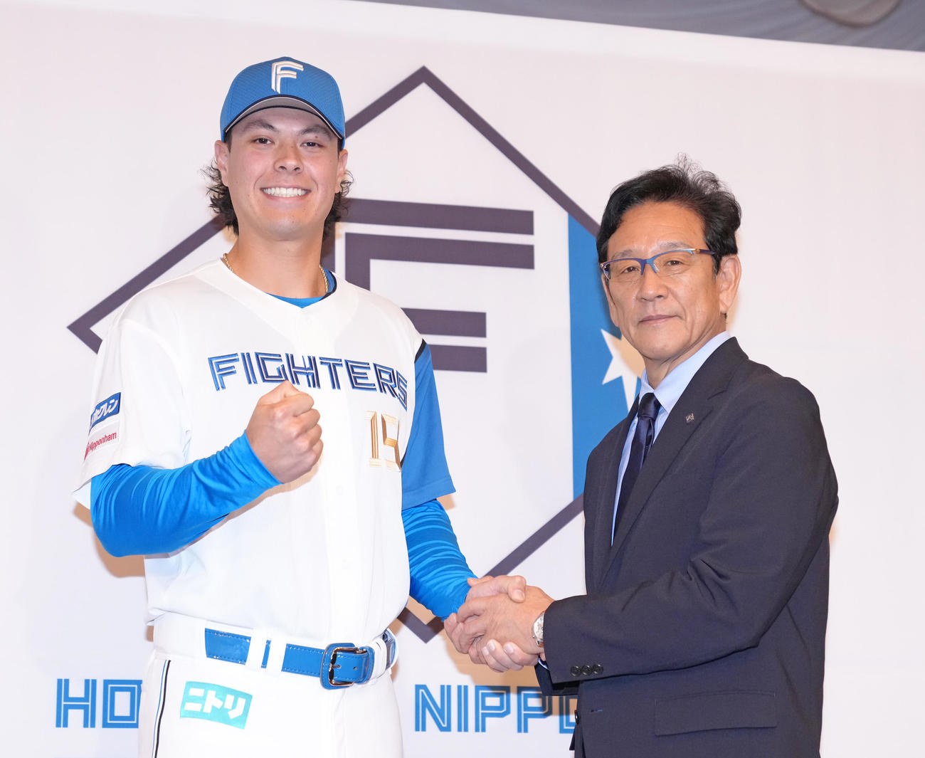 日本ハムと育成契約を結んだマイカ与那嶺（左）は栗山CBOと笑顔で握手を交わす（撮影・足立雅史）