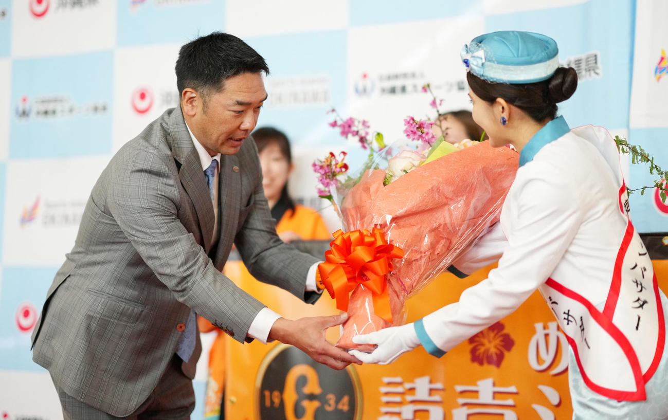 那覇空港に到着し花束を受け取る巨人阿部監督（撮影・横山健太）