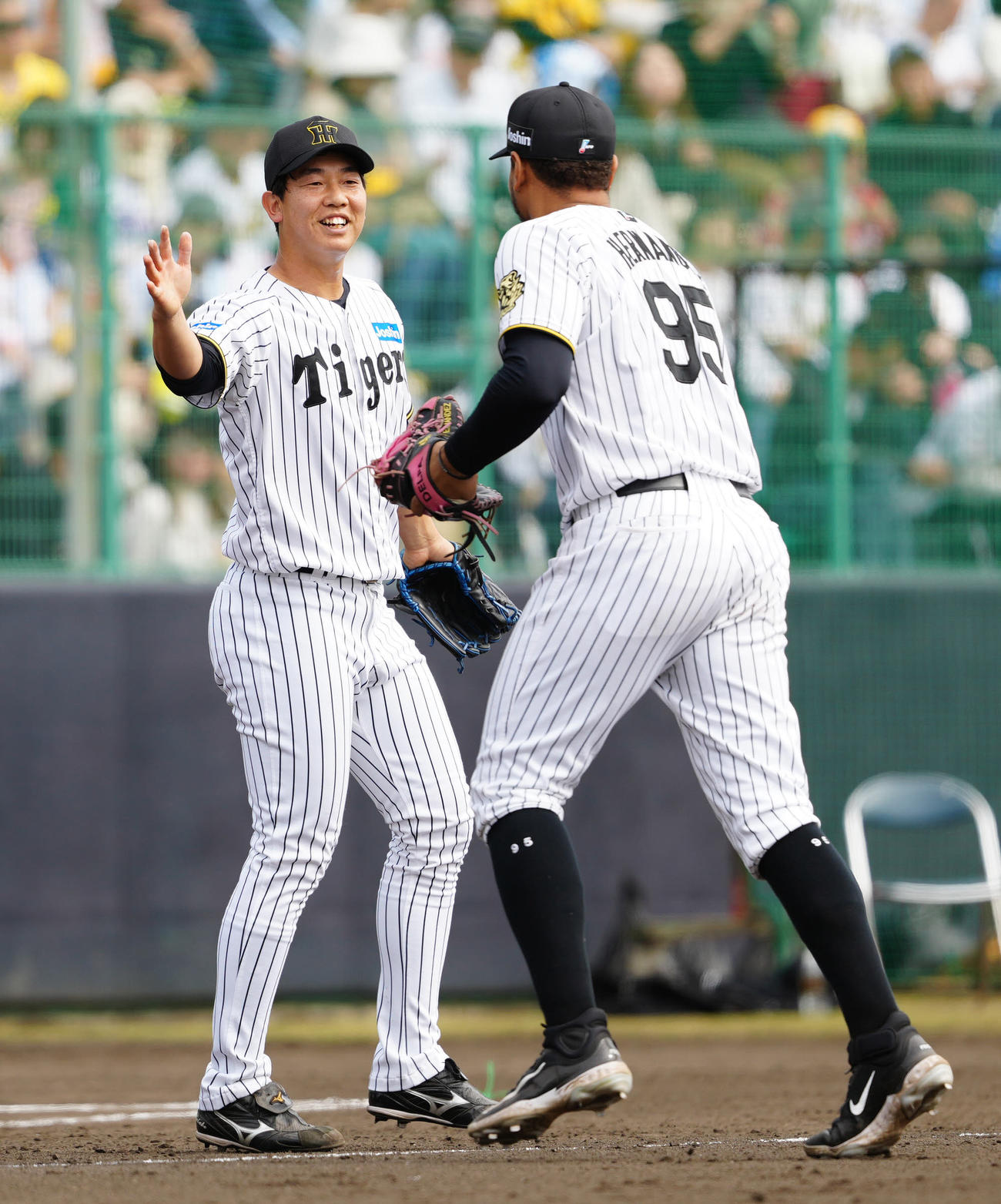 阪神対楽天　5回表終了後、阪神ヘルナンデス（右）とタッチを交わす3番手の畠（撮影・江口和貴）
