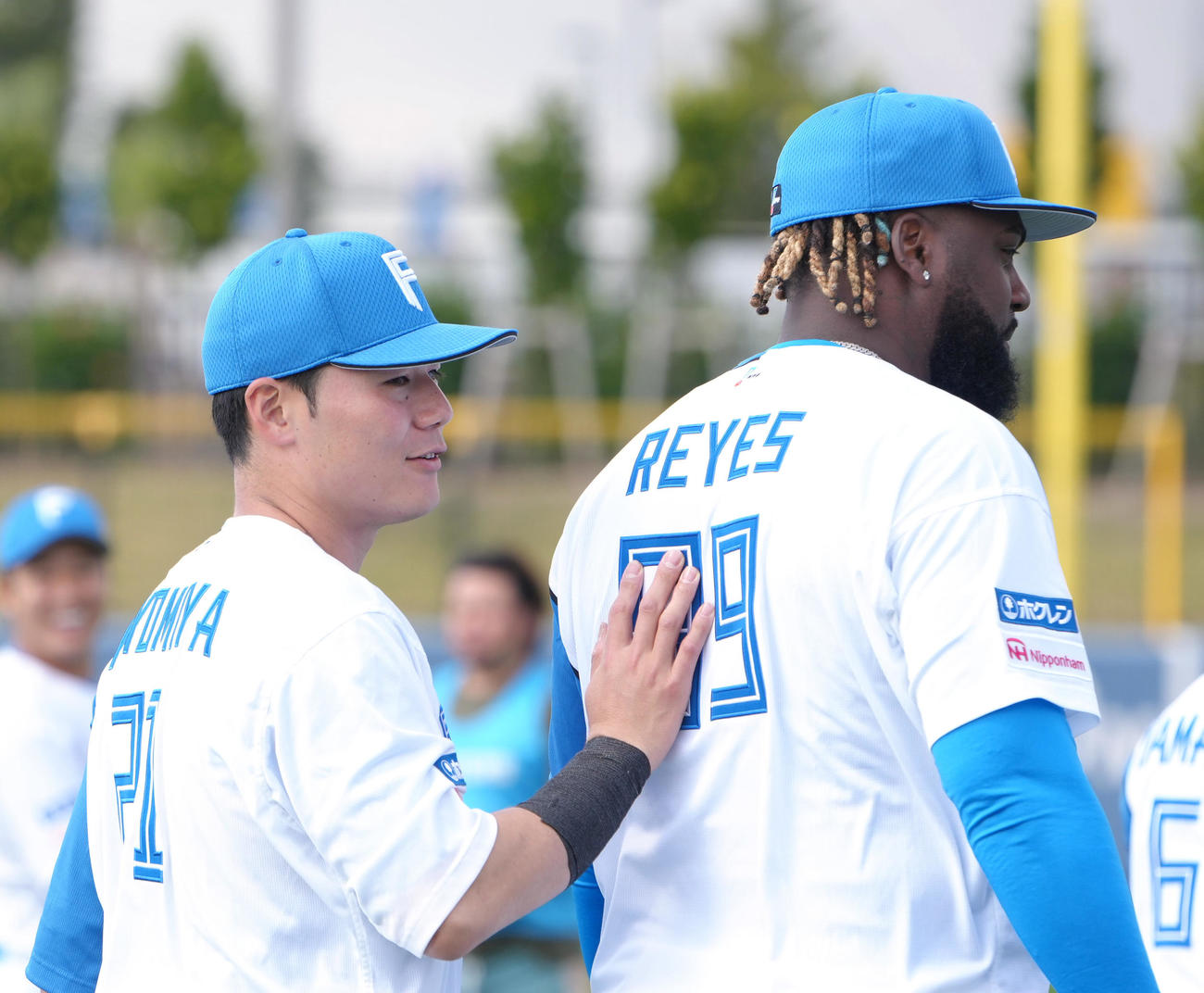 集合写真撮影を終えた日本ハム清宮幸（左）はこの日合流したレイエスの背中を押す（撮影・足立雅史）