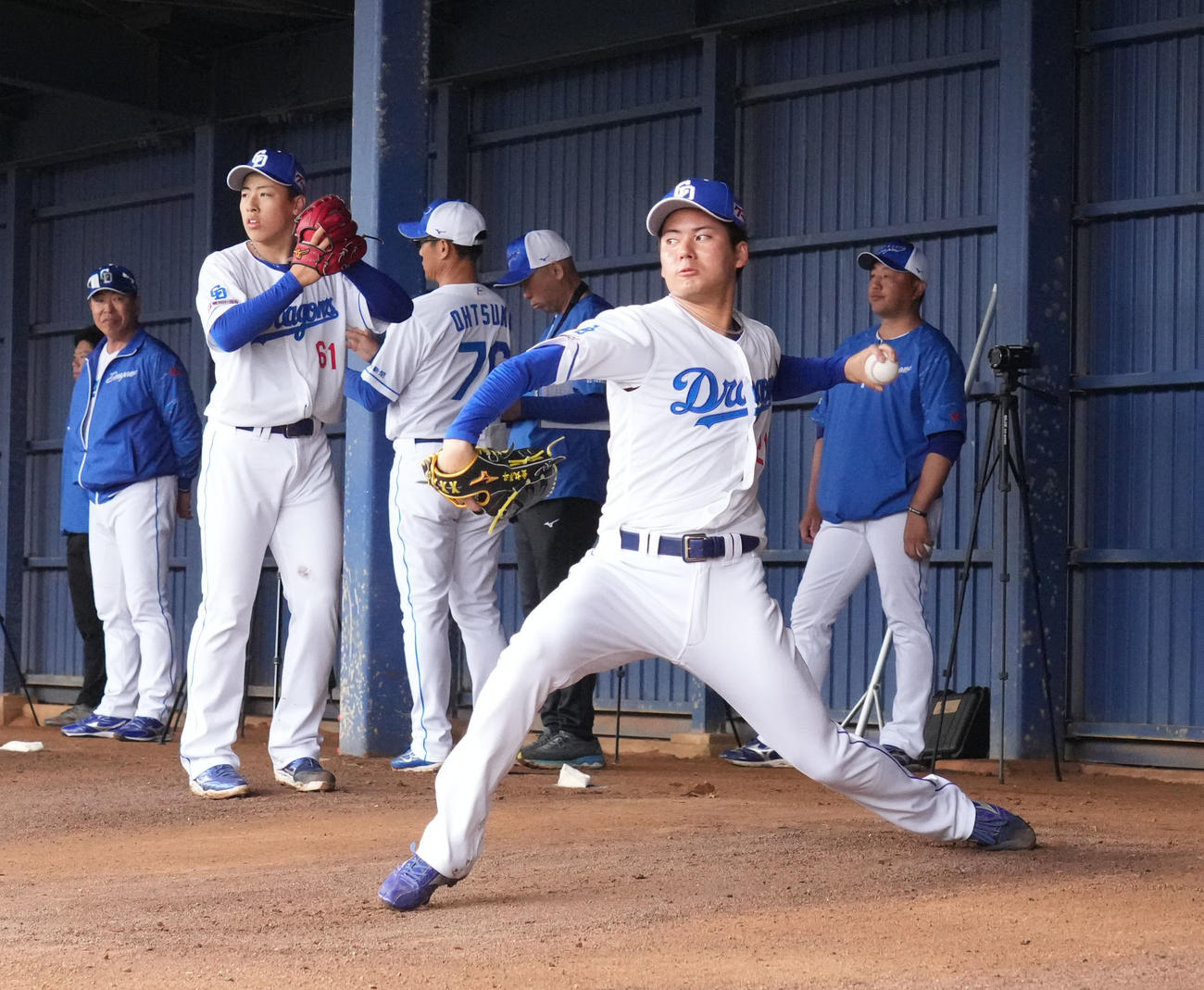 ブルペンで投球練習をする金丸（手前・右）左奥は井上監督（撮影・森本幸一）
