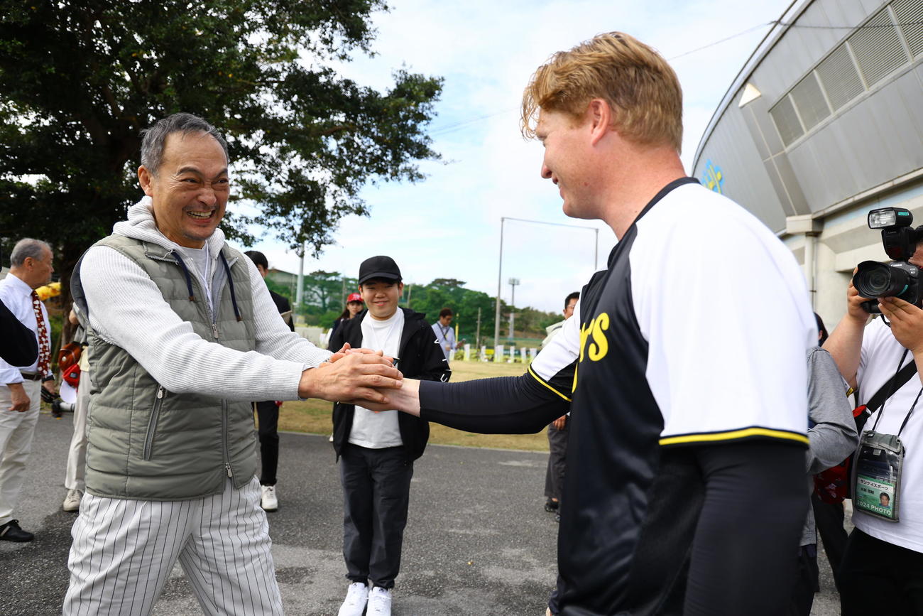 ネルソン（右）と握手をする俳優の渡辺謙（撮影・藤尾明華）