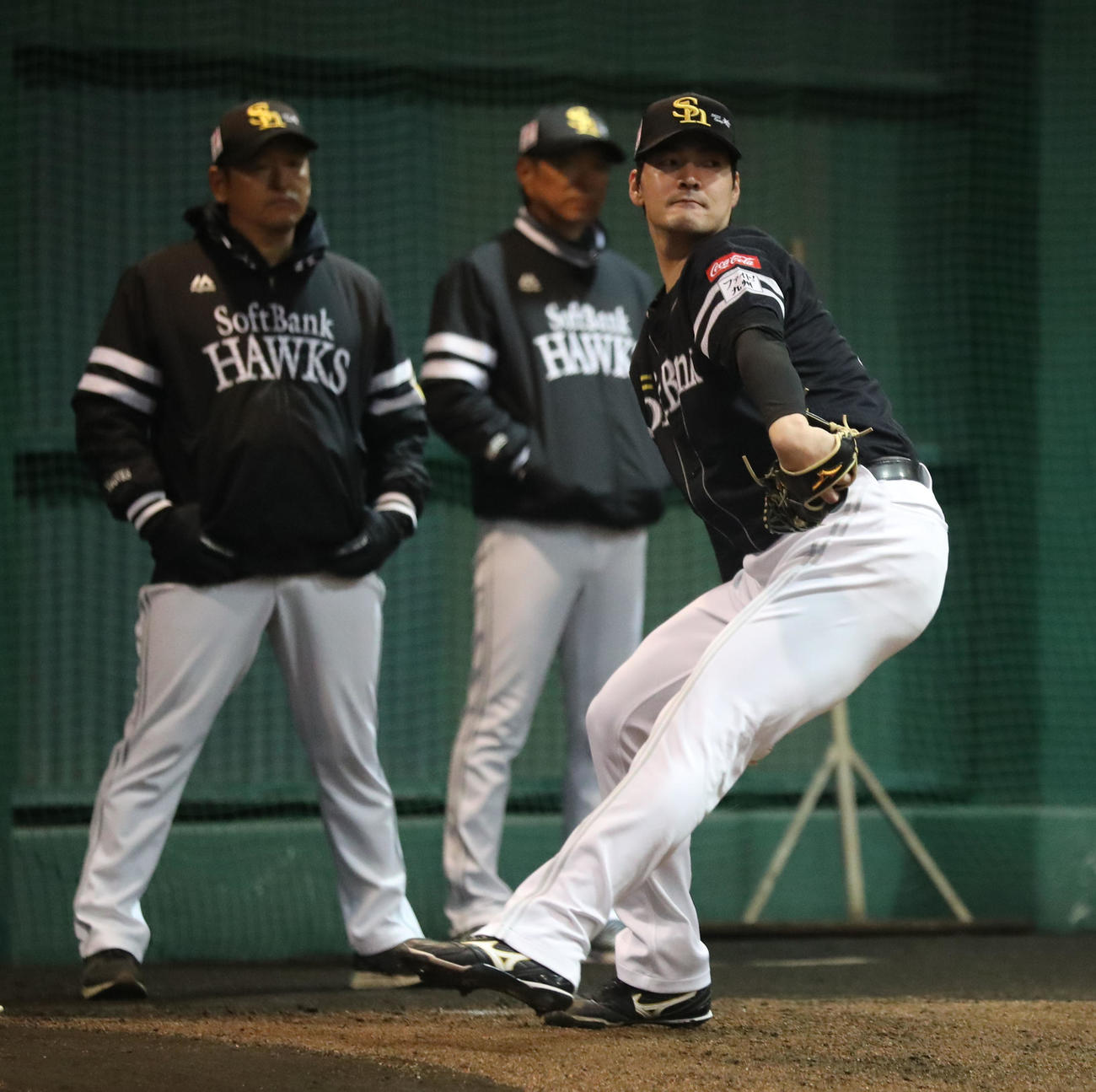 ブルペンに入った有原は力強く投げ込む、後方は左から倉野コーチと小久保監督（撮影・梅根麻紀）