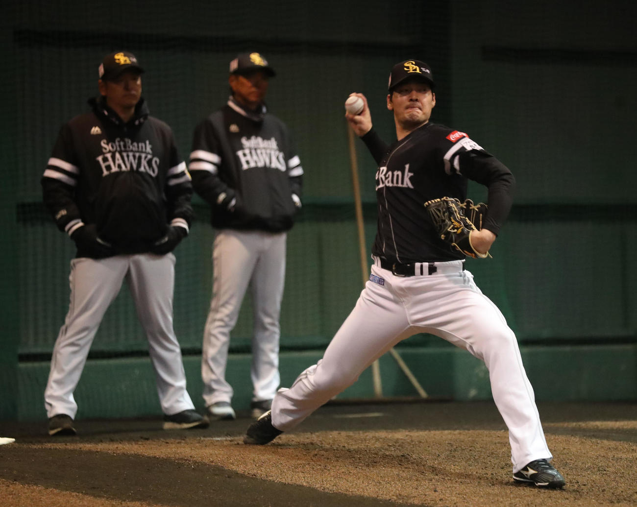 ブルペンに入った有原は力強く投げ込む、後方は左から倉野コーチと小久保監督（撮影・梅根麻紀）