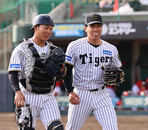 練習試合阪神対広島 8回を抑え、藤田(左)と笑顔でベンチに戻る工藤(撮影・藤尾明華)