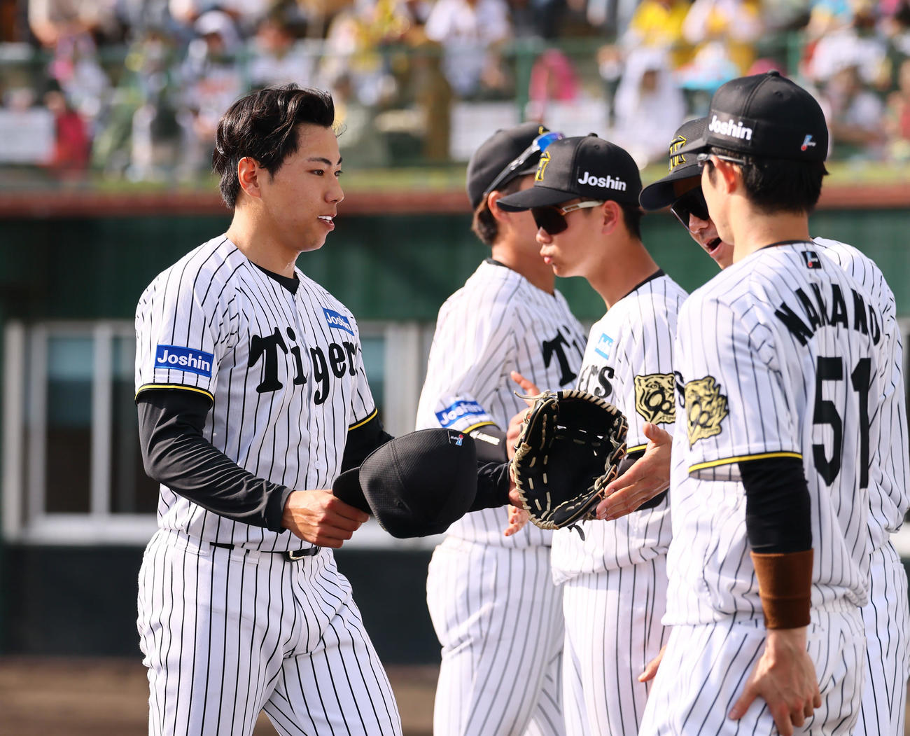 練習試合阪神対広島　8回を終え、ベンチ前で出迎えられる工藤（左端）（撮影・藤尾明華）