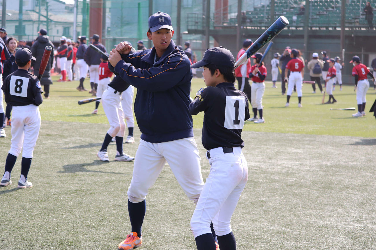 中原区野球教室で、小学生に熱心に打撃指導をする、法大・松下主将（撮影・保坂淑子）