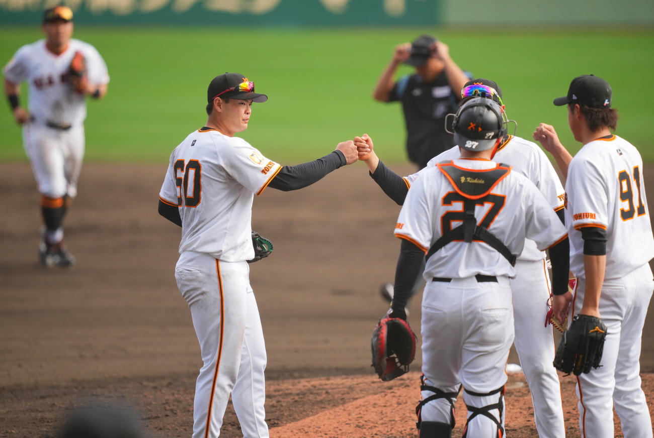 巨人対サムスン　サムスンに勝利しタッチを交わす荒巻（左）ら巨人ナイン（撮影・垰建太）