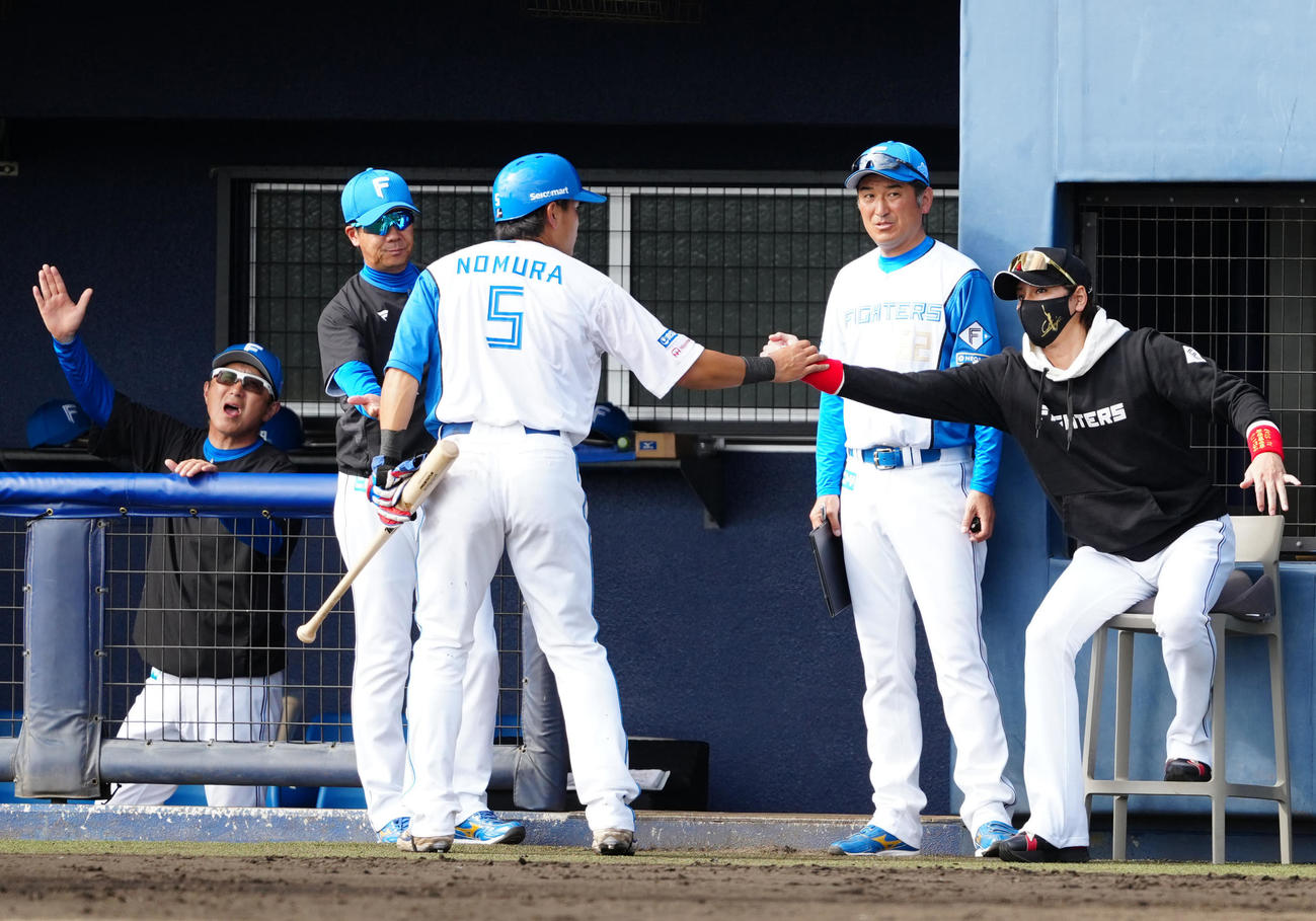 日本ハム対楽天　6回裏終了後、日本ハム野村（中央）とタッチを交わす新庄監督（右端）（撮影・江口和貴）