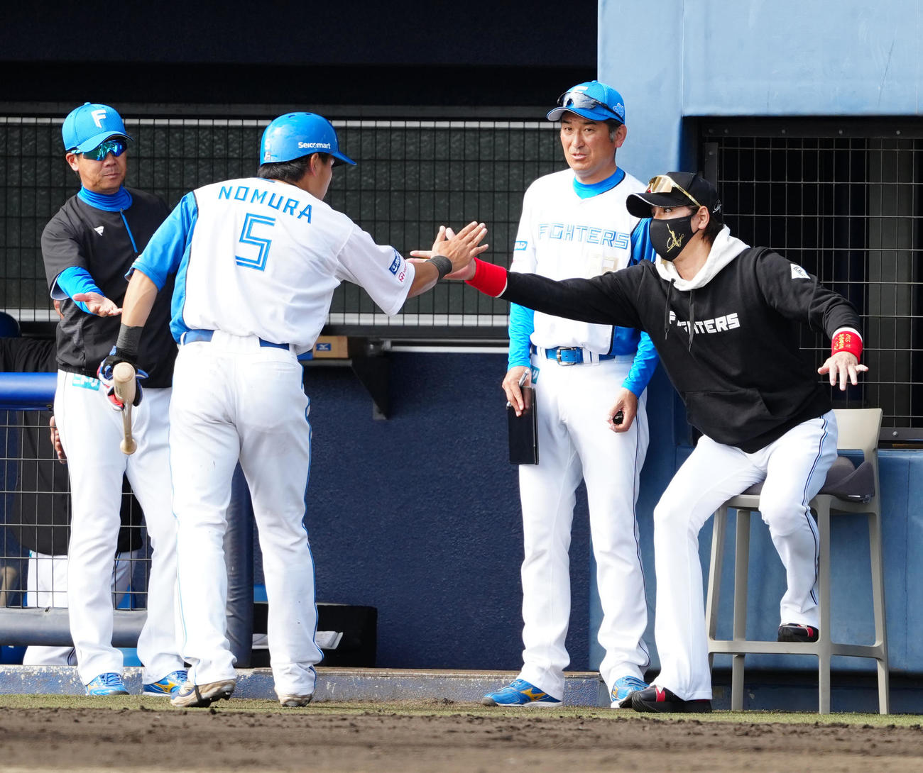 日本ハム対楽天　6回裏終了後、日本ハム野村（左から2人目）とタッチを交わす新庄監督（撮影・江口和貴）