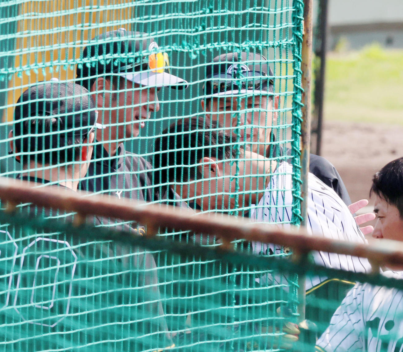 藤川監督（左）の前でシート打撃練習に登板した湯浅は握手を求められ、頭を下げる（撮影・加藤哉）