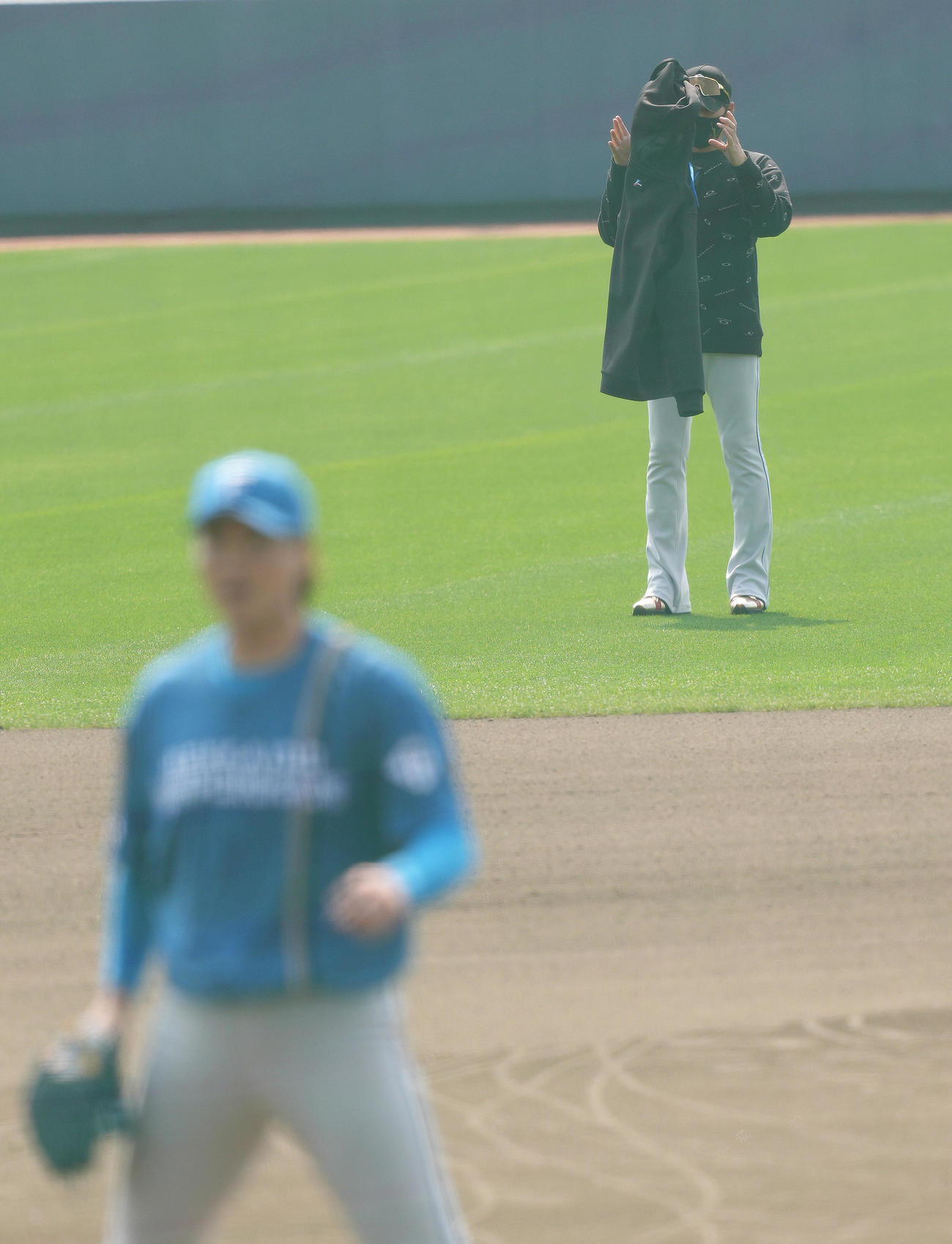 ライブBPに登板した日本ハム山崎（手前）を見つめていた新庄監督は上着を脱ぐ（撮影・足立雅史）