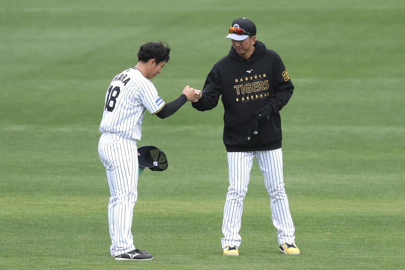 ライブBPの登板を終えた阪神伊原（左）とグータッチを交わす藤川監督（撮影・前田充）