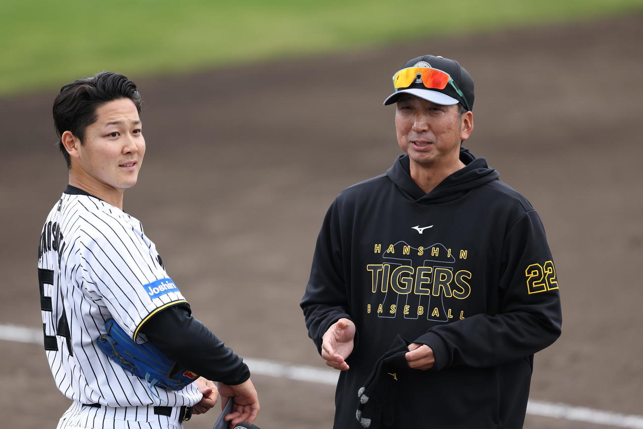 ライブBPの登板を終えた阪神木下（左）と言葉を交わす藤川監督（撮影・前田充）