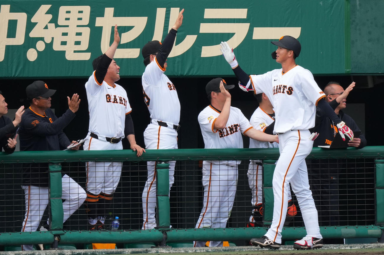 巨人対DeNA 7回裏巨人1死一塁、右越え2点本塁打を放ちナインとタッチを交わす秋広（右から2人目）（撮影・横山健太）