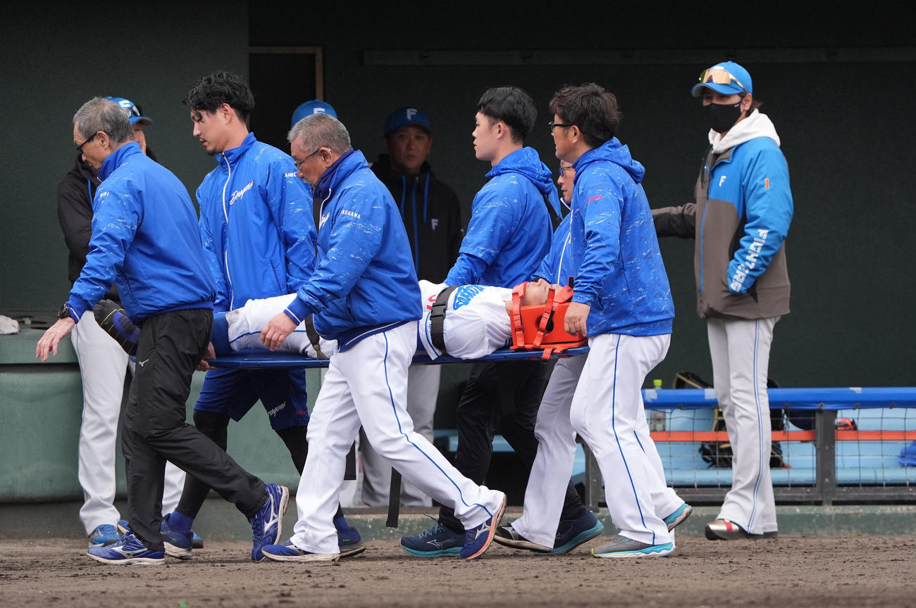 中日対日本ハム　8回表日本ハム2死一塁、マルティネスの打球を追いフェンスに激突し担架で運ばれる樋口。右端は心配そうに見つめる日本ハム新庄監督（撮影・森本幸一）