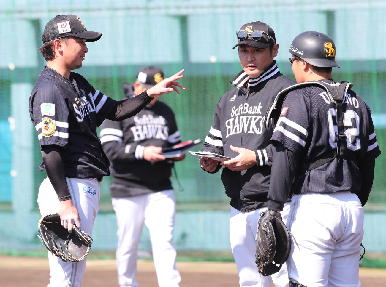 ライブBP登板を終えた東浜（左）は、受けた海野（右）や中田コーチと話し合う（撮影・梅根麻紀）