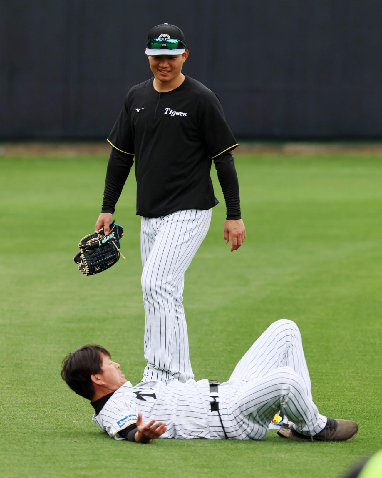 打撃練習開始前、外野でストレッチ運動する筒井コーチ（左）に声を掛ける森下（撮影・加藤哉）