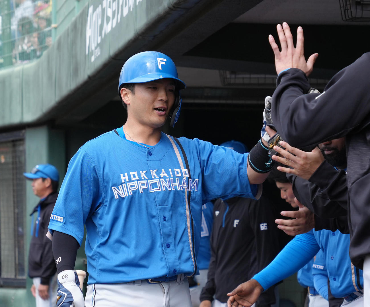 中日対日本ハム　2回表日本ハム2死三塁、石井の適時二塁打で生還し、タッチを交わす郡司（撮影・足立雅史）