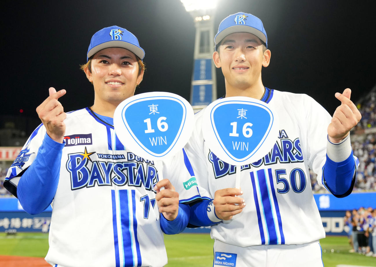 23年9月26日、16勝目をあげうちわを手に笑顔を見せるDeNA東。右は山本
