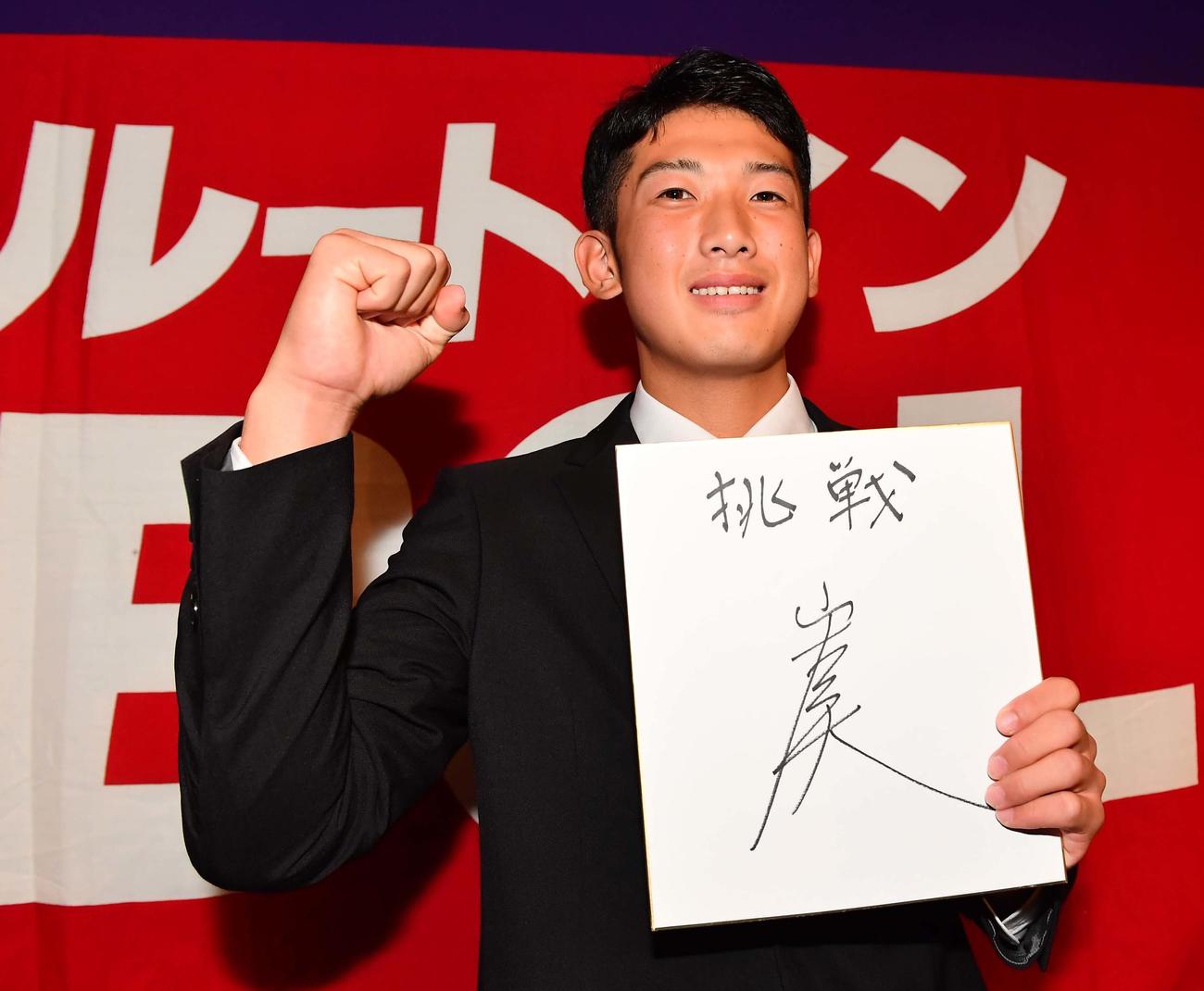 17年10月26日、DeNAから9巡目で指名され色紙を手に笑顔を見せる滋賀ユナイテッドベースボールの山本祐大