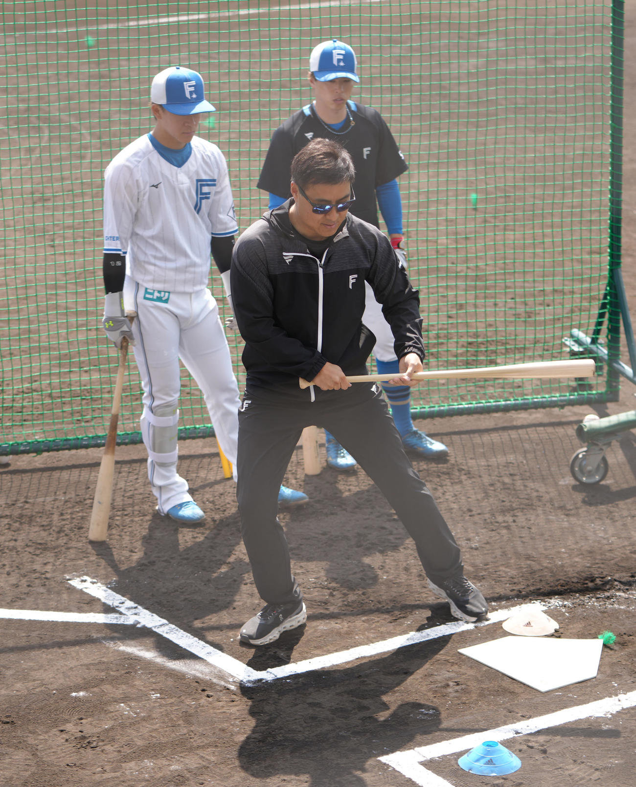 日本ハムの矢沢（後方左）、五十幡（同右）にバント指導する田中SA（撮影・足立雅史）