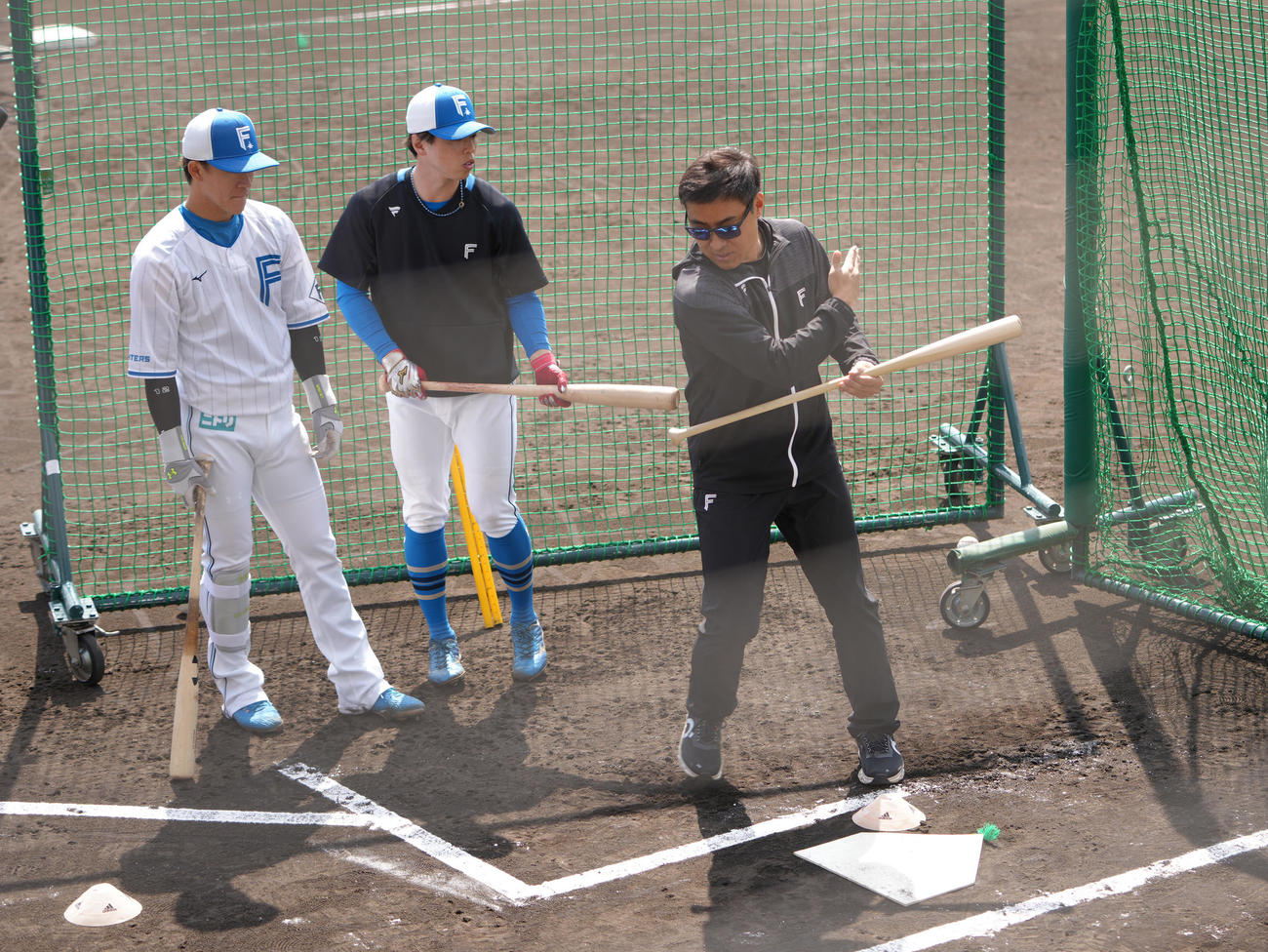 日本ハムの矢沢（左）、五十幡（中央）にバント指導する田中SA（撮影・足立雅史）