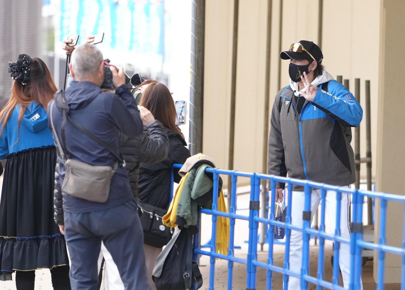 球場入りした日本ハム新庄監督はファンのカメラに笑顔で応える（撮影・足立雅史）