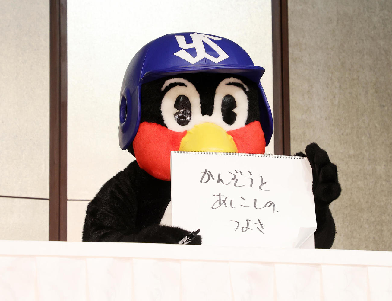 つば九郎2000試合出場フライング会見　「かんぞうとあしこしのつよさ」と書いたヤクルトのマスコットつば九郎＝2022年8月5日　